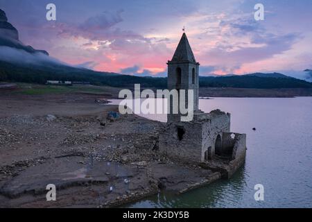 Glockenturm von Sau während der Dürre von 2022 vollständig ausgesetzt. Roter Sonnenaufgang im Sumpf (Osona, Barcelona, Katalonien, Spanien) ESP: Campanario de Sau Stockfoto