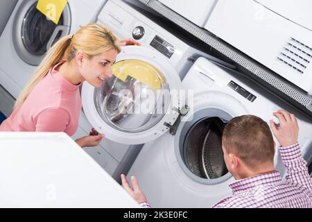 Familie, die sich für eine Waschmaschine entscheidet Stockfoto