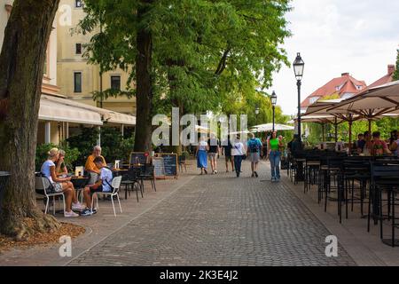 Ljubljana, Slowenien - September 3. 2022. Eine verkehrsreiche Fußgängerzone mit Bars und Restaurants an der Uferpromenade des Flusses Ljubljanici Stockfoto