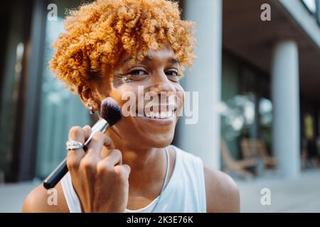 afroamerikanischer Visagist, der Pinsel hält und Make-up vorbereitet Stockfoto