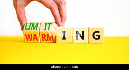 Symbol für Begrenzung der globalen Erwärmung. Konzept Worte Begrenzung und Erwärmung auf Holzwürfel. Geschäftsmann Hand. Schöne gelbe Tabelle weißen Hintergrund. Unternehmen Stockfoto