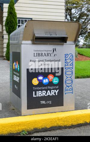 Raymond, WA, USA - 14. September 2022; Metallbuch-Drop-Box neben gelbem Curb in der Raymond Timberland Library Stockfoto