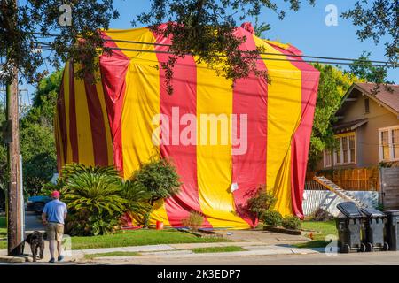 NEW ORLEANS, LA, USA - 23. SEPTEMBER 2022: Großes Haus in gelb-rotem Zelt während der Begasung für Schädlinge in Uptown Nachbarschaft Stockfoto