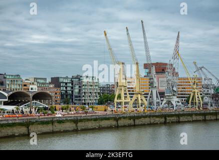 Antwerpen, Flandern, Belgien - 10. Juli 2022: Entlang Der Schelde. Sammlung historischer Kraniche am Kai mit Waagnatie-Lagerhäusern links und Friendschi Stockfoto