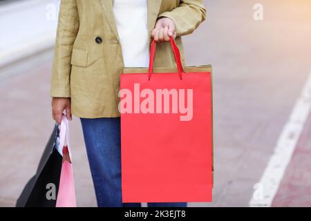 Nicht erkennbare Frau mit bunten Einkaufstaschen mit Mockup in der städtischen Stadtstraße. Käufe, schwarzer freitag, Rabatte, Verkaufskonzept. Online-Shopping Stockfoto