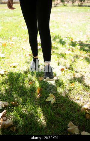 Junge Frau mit Sportschuhen joggt im Park. Stockfoto