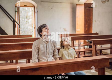 Christian Papa erzählt seinem Sohn biblische Geschichten über Jesus in kirk sitzen. Glaube, Religionsunterricht, moderne Kirche, Vatertag, väterliche Stockfoto