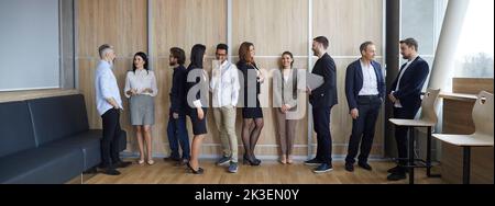 Verschiedene Gruppen von Personen, die nach einer Geschäftskonferenz oder einem Unternehmensmeeting kommunizieren Stockfoto