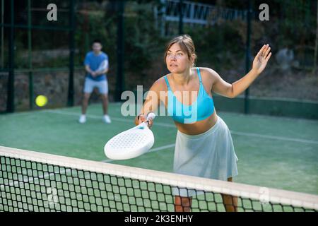 Fit junge Frau spielt Padel Tennis auf dem offenen Platz Stockfoto