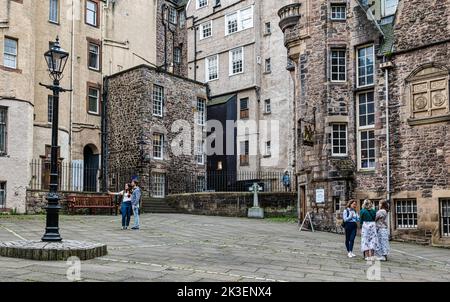 Touristen, die ein Selfie in einem Innenhof neben der Royal Mile vor dem Writer's Museum, Makar's Court, Edinburgh, Schottland, Großbritannien, machen Stockfoto