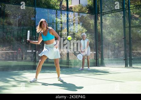 Frau, die während des Trainings auf dem Platz mit dem Padel spielt Stockfoto