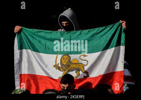 London, Großbritannien. 26. September 2022. Ein Protestler hält eine Löwe-Sonne-Flagge des Iran. Nach dem Tod von Mahsa Amini, der in Polizeigewahrsam im Iran starb, nachdem er festgenommen worden war, weil er angeblich in der Öffentlichkeit kein Kopftuch (Hijab) „ordnungsgemäß“ trug, versammeln sich die Demonstranten weiterhin vor der Botschaft des Iran in London. Kredit: Vuk Valcic/Alamy Live Nachrichten Stockfoto