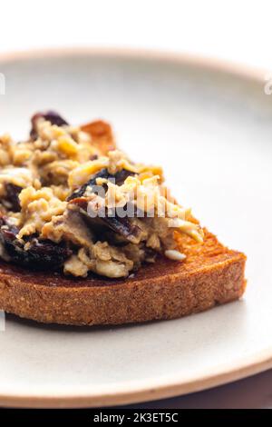 Geröstetes Brot serviert mit Rührei und Pilzen Stockfoto