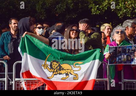 London, Großbritannien. 26. September 2022. Ein Protestler hält eine Löwe-Sonne-Flagge des Iran. Nach dem Tod von Mahsa Amini, der in Polizeigewahrsam im Iran starb, nachdem er festgenommen worden war, weil er angeblich in der Öffentlichkeit kein Kopftuch (Hijab) „ordnungsgemäß“ trug, versammeln sich die Demonstranten weiterhin vor der Botschaft des Iran in London. Kredit: Vuk Valcic/Alamy Live Nachrichten Stockfoto