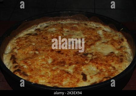 Portion Cannelloni mit Fleisch, Sahnesauce und Käse in einem Tontopf. Italienisches Küchenkonzept Stockfoto