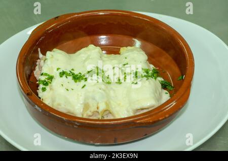 Portion Cannelloni mit Fleisch, Sahnesauce und Käse in einem Tontopf. Italienisches Küchenkonzept Stockfoto