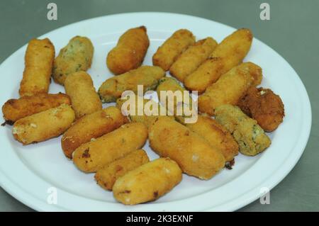 Käse- und Spinatleckereien auf dem weißen Teller. Stockfoto