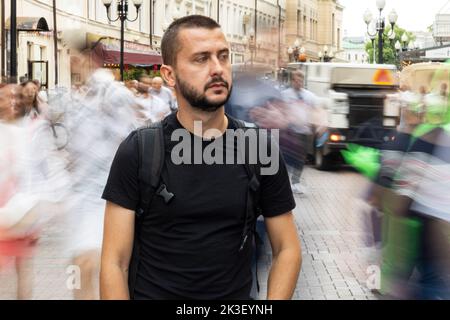 Trauriger junger, erwachsener kaukasischer Mann in einer Menge Stockfoto