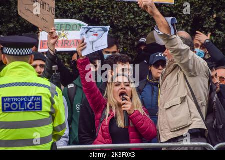 London, England, Großbritannien. 26. September 2022. Ein Protestler hält ein Bild von Mahsa Amini, während er Slogans auf einem Mikrofon singt. Die Demonstranten versammeln sich weiterhin vor der iranischen Botschaft in London als Reaktion auf den Tod von Mahsa Amini, der in Polizeigewahrsam im Iran starb, nachdem er festgenommen worden war, weil er angeblich in der Öffentlichkeit kein Kopftuch (Hijab) „richtig“ trug. (Bild: © Vuk Valcic/ZUMA Press Wire) Stockfoto