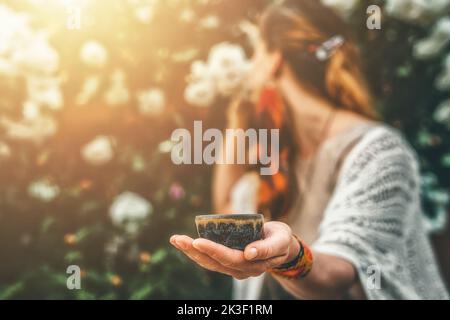 Kakaozeremonie im Garten, herzöffnende Medizin. Zeremonienraum. Rosenhintergrund. Stockfoto
