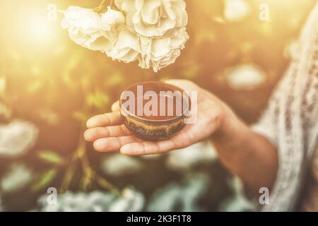 Kakaozeremonie im Garten, herzöffnende Medizin. Zeremonienraum. Rosenhintergrund. Stockfoto