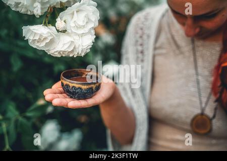 Kakaozeremonie im Garten, herzöffnende Medizin. Zeremonienraum. Rosenhintergrund. Stockfoto
