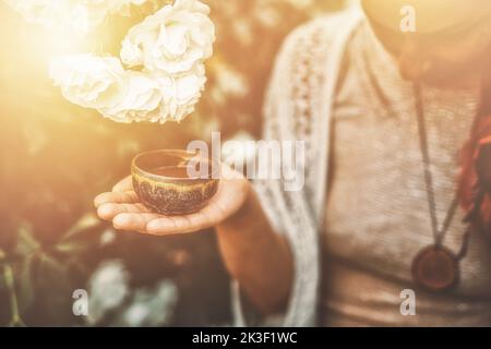 Kakaozeremonie im Garten, herzöffnende Medizin. Zeremonienraum. Rosenhintergrund. Stockfoto