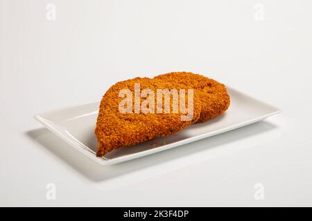 Hühnerschnitzel mit Kräutern auf einem weißen Teller Stockfoto