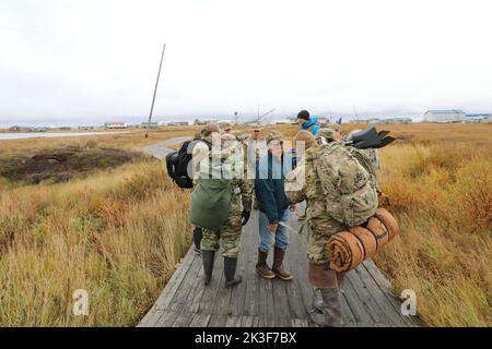 US-Soldaten mit der Alaska National Guard machen sich nach der Landung auf den Weg in ein winziges Küstendorf, um den Anwohnern nach dem Taifun Merbok, 22. September 2022 in Newtok, Alaska, bei der Säuberung zu helfen. Die abgelegenen Dörfer der Ureinwohner Alaskas wurden über mehr als 1.000 Meilen der Küste Alaskas überflutet. Stockfoto