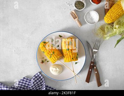 Teller mit schmackhaftem Mais auf weißem Hintergrund, Draufsicht, Kopierbereich Stockfoto