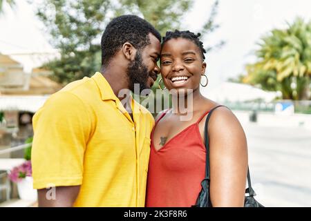 Das junge afirquinamerikanische Paar lächelt glücklich und umarmt die Stadt. Stockfoto