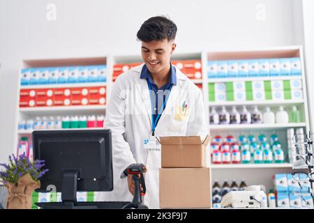 Junger hispanischer Apotheker, der Pillen in der Apotheke scannt Stockfoto