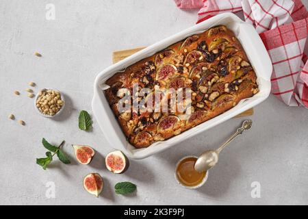 Köstlicher Kuchen mit frischen Feigen, Blauschimmelkäse, Pinienkernen und Honig auf hellem Tisch, Draufsicht, Kopierraum Stockfoto