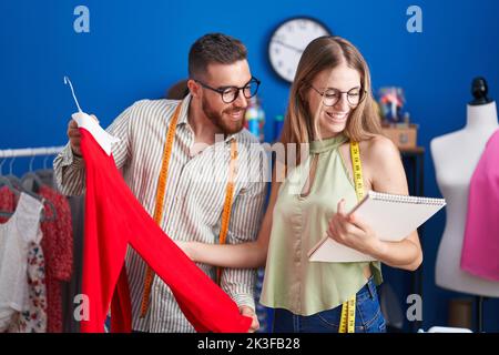 In der Bekleidungsfabrik Schneiderinnen und Schneiderinnen, die T-Shirt im Look halten Stockfoto