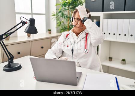 Leitender Arzt Mann, der auf Online-Termin überrascht mit Hand auf Kopf für Fehler, erinnern Fehler. vergessen, schlechtes Gedächtnis-Konzept. Stockfoto