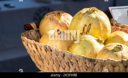 Grün-gelbe Granaten in einem Korbkorb aus der Nähe Stockfoto