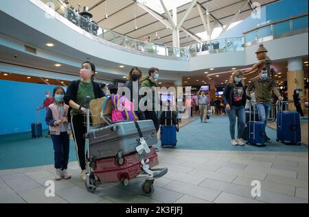 Richmond, Kanada. 26. September 2022. Reisende mit Gesichtsmasken kommen am 26. September 2022 am Vancouver International Airport in Richmond, Kanada, an. Die kanadische Bundesregierung kündigte am Montag die Aufhebung aller COVID-19-Einreisebeschränkungen sowie der Prüf-, Quarantäne- und Isolationsanforderungen für Personen an, die nach Kanada einreisen, mit Wirkung vom 1. Oktober an. Quelle: Liang Sen/Xinhua/Alamy Live News Stockfoto