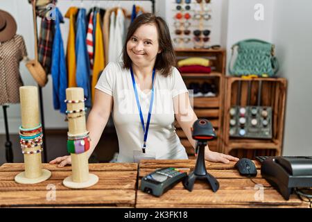 Brünette Frau mit Down-Syndrom lächelnd arbeitet als Verkäuferin im Einzelhandel Stockfoto