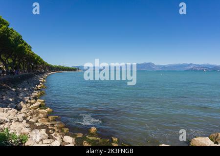 Panoramablick auf den Strand von Desenzano am Gardasee, Panorama auf die Brescia-Seite des touristischen Sees Norditaliens Stockfoto