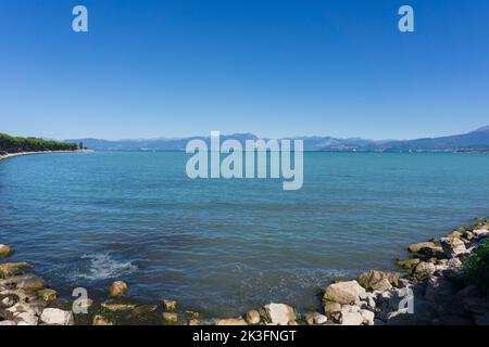 Panoramablick auf den Strand von Desenzano am Gardasee, Panorama auf die Brescia-Seite des touristischen Sees Norditaliens Stockfoto