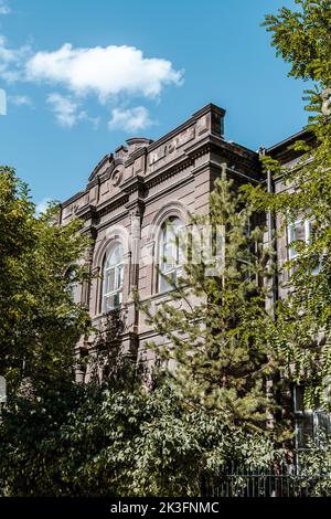 Außenansicht eines alten, historischen und klassischen Stadtgebäudes in Kars, Türkei mit grünem Garten. Hochwertige Fotos Stockfoto