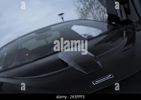 Die aerodynamische Front Aftermarket Carbon Fiber NOVITEC Motorhaube auf Einem 2019 Cosmos Black McLaren 600LT mit schwarzem McLaren Motorhaube-Abzeichen Stockfoto