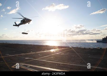 Ein MH-60s Nighthawk, der an den 'Tridenten' des Helicopter Sea Combat Squadron (HSC) 9 befestigt ist, nähert sich während einer Munitionsaufladung am 25. September 2022 dem Flugdeck des ersten Flugzeugträgers USS Gerald R. Ford (CVN 78). Ford führt derzeit im Atlantischen Ozean Qualifizierungen von Fluggesellschaften durch und arbeitet für einen geplanten Einsatz im Herbst. (USA Navy Foto von Mass Communication Specialist 1. Class William Spears) Stockfoto