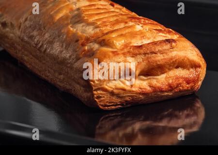 Ein gebackenes hausgemachtes Brötchen mit Apfelmarmelade im Elektroofen: Nahaufnahme Stockfoto