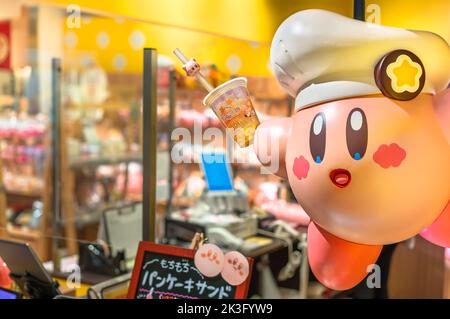 tokio, japan - Sept. 21 2022: Kirby-Figur, die Nintendo-Spielfigur mit rosafarbenem Ball, trägt einen Hauben-Hut wie ein Koch und hält eine Tasse Bubble-Tee Stockfoto