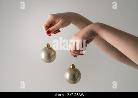 Hand von unbekannten kaukasischen Frau halten Weihnachtsdekoration in der Hand vor weißem Hintergrund kopieren Raum Neujahr Feier Konzept Stockfoto