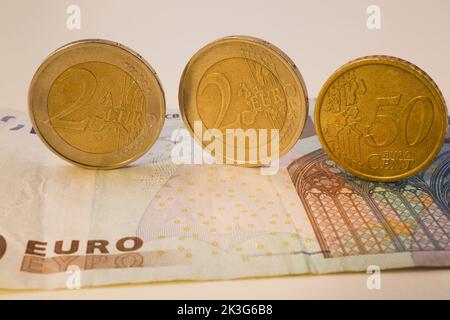 Nahaufnahme von drei verschiedenen Euro-Münzen auf einer 20-Euro-Banknote. Stockfoto