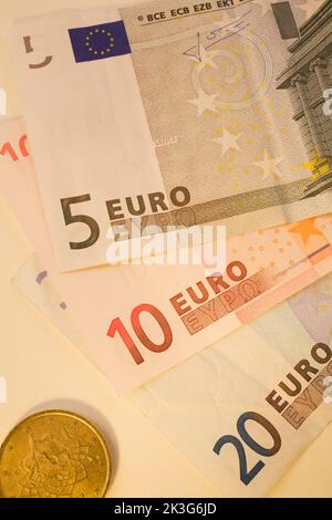 Nahaufnahme von 5, 10, 20 Euro-Banknoten und Münzen auf weißem Hintergrund. Stockfoto