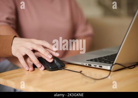 Hand eines Enkels, der Großmutter mit Computermaus unterrichtete Stockfoto