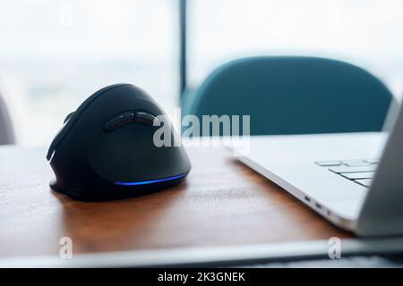 Ergonomische Maus auf dem Schreibtisch am Arbeitsplatz, Vermeidung von Schmerzen am Handgelenk, weil lange gearbeitet wird. De Quervain s tenosynovitis, Kreuzungssymptom, Schottenmuster Stockfoto